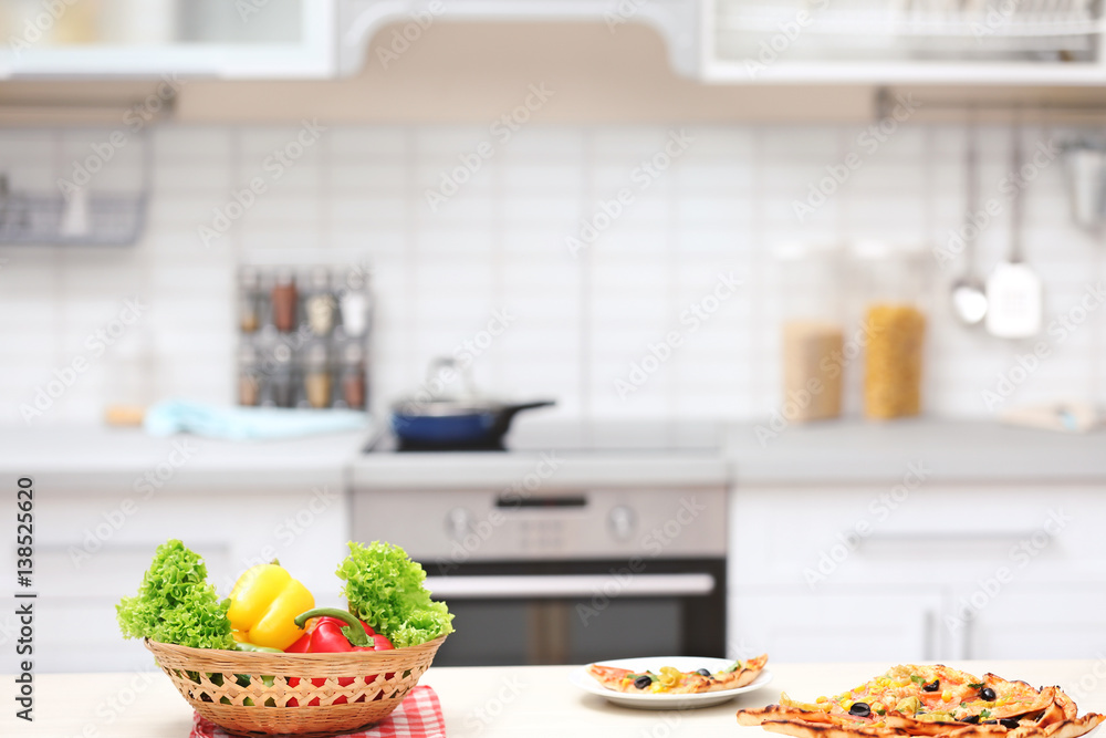 Vegetables and tasty pizza on kitchen table Vegetables and tasty pizza on kitchen table