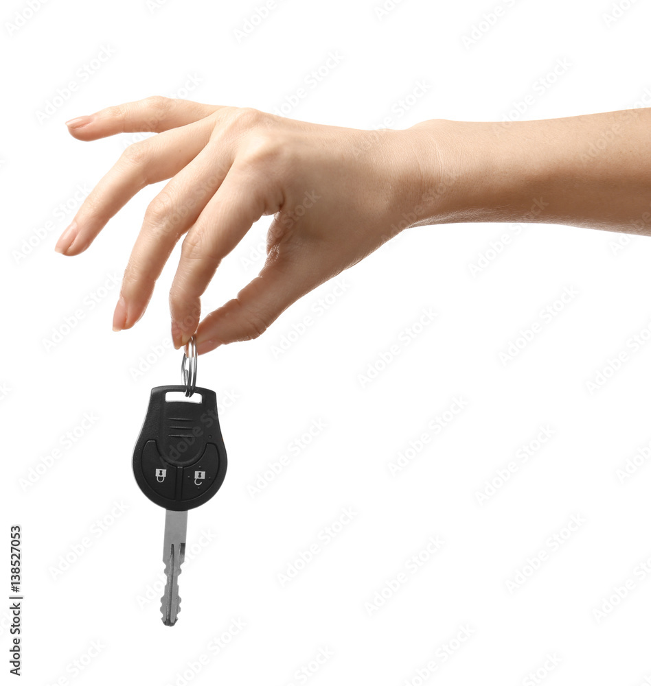 Female hand holding car keys on white background Female hand holding car keys on white background
