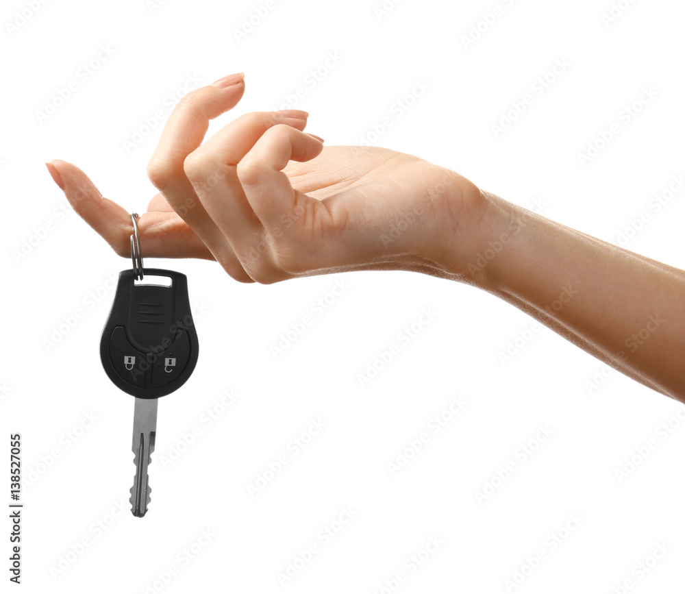 Female hand holding car keys on white background Female hand holding car keys on white background