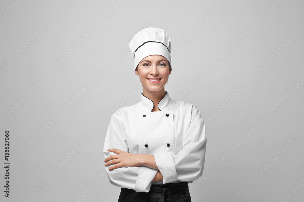 Portrait of female chef on light grey background Portrait of female chef on light grey background