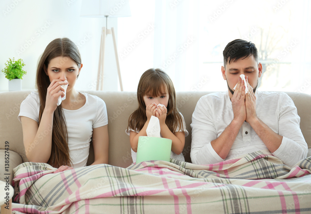 Ill family sitting on sofa at home