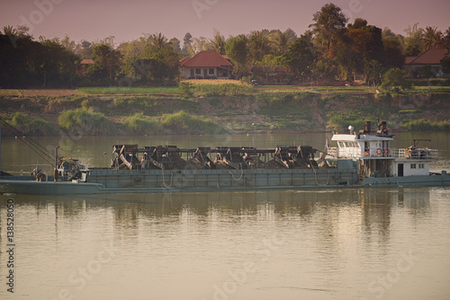 Laos - February 26, 2017. A cargo boat carrying sand on the Mekong River in Southern Laos.