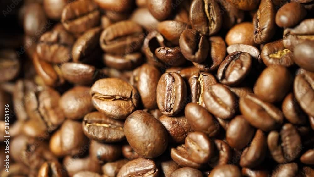 Game of light and shade on lying motionless some fresh coffee beans, close up top view Game of light and shade on lying motionless some fresh coffee beans, close up top view