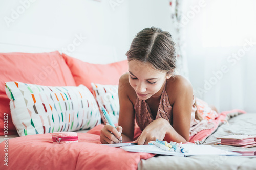 Pre teen girl writing diary photo