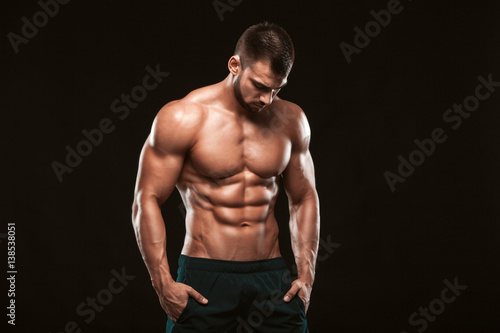 Fotografia Strong Athletic Man - Fitness Model showing his perfect back isolated on black b