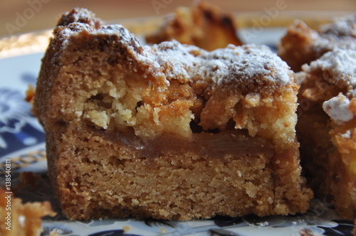 Apple pie dusted with icing sugar on the kitchen table.