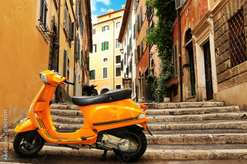 Fototapeta Pomarańczowa rocznik hulajnoga na tle Rzym ulica