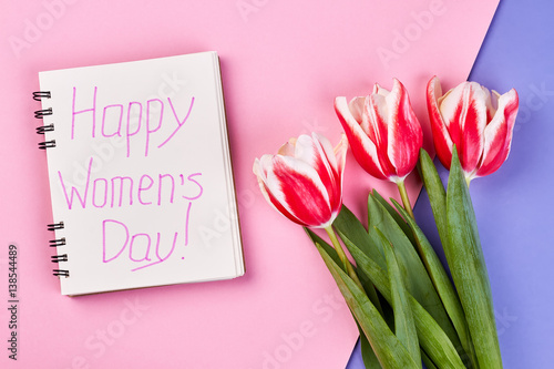 Notebook and red tulips. Congratulation with Women's day.