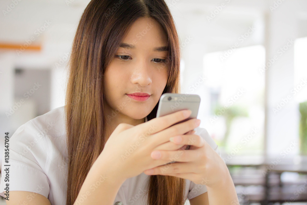 Portrait of thai adult student university uniform beautiful girl using her smart phone Portrait of thai adult student university uniform beautiful girl using her smart phone