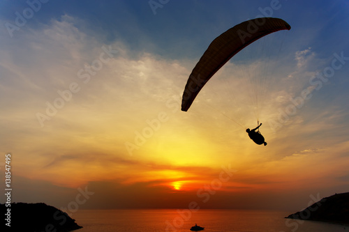 Paraglider silhouette against the background of the sunset sky