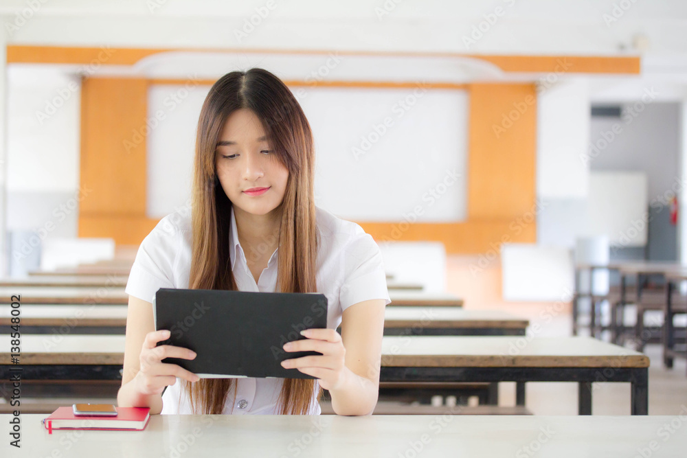 Portrait of thai adult student university uniform beautiful girl using her tablet. Portrait of thai adult student university uniform beautiful girl using her tablet.