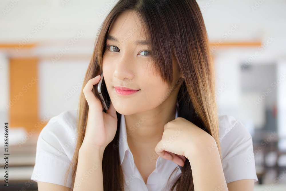 Portrait of thai adult student university uniform beautiful girl calling smart phone Portrait of thai adult student university uniform beautiful girl calling smart phone