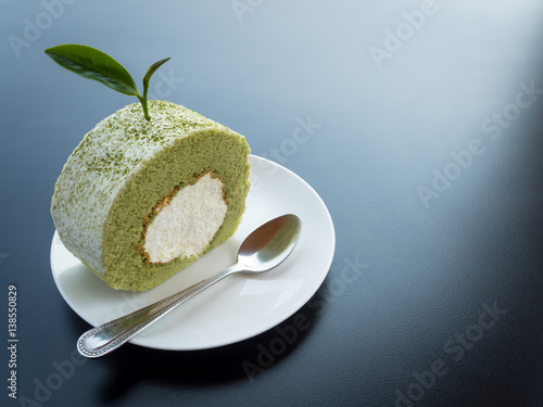 Close-up image of green tea roll cake with tea leave on table, Copy space