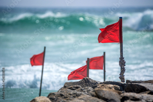 Red warning flag on beach photo