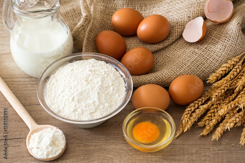 top view eggs, flour and baking ingredients on wooden table .