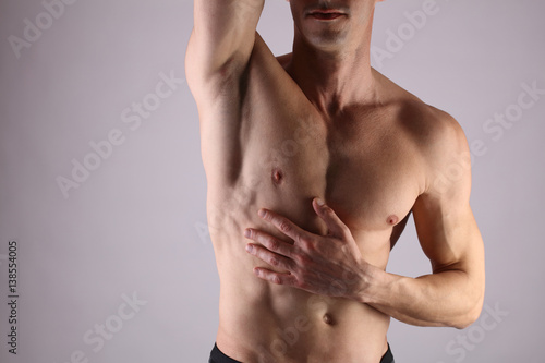 Close up of muscular male torso, chest and armpit hair removal. Male Waxing photo