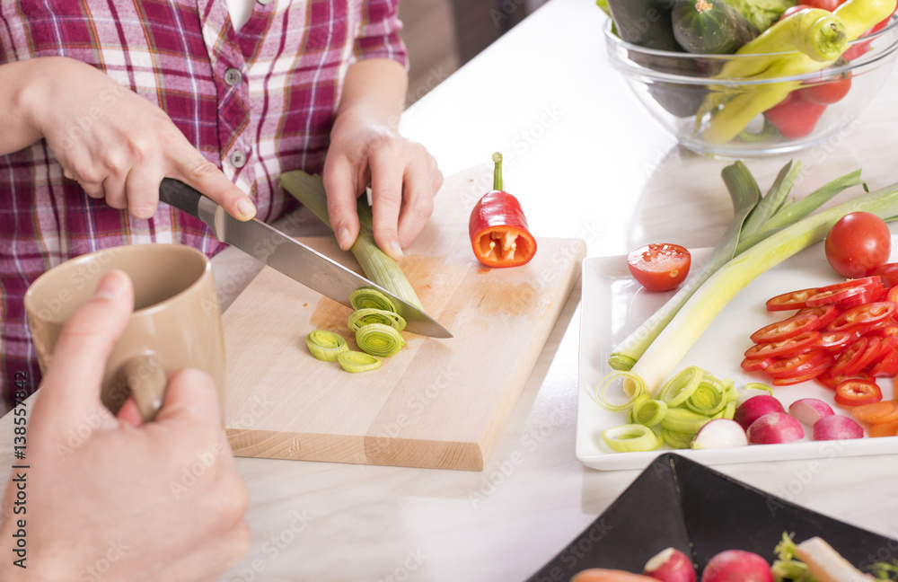 Close up of woman in the kitchen while preparing fresh vegetable salad Close up of woman in the kitchen while preparing fresh vegetable salad