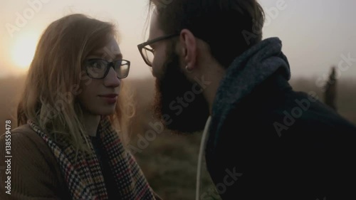 A quarrel between a man and a woman on sunset background