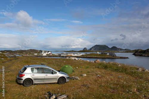 Fototapeta Naklejka Na Ścianę i Meble -  Auto und Zelt auf einer Wiese an einer Bucht mit Inselchen, im Hintergrund Gjesvaer und die Insel Storstappen in der Nähe des Nordkapp. Mageroya, Norwegen – Camping als Jedermannsrecht
