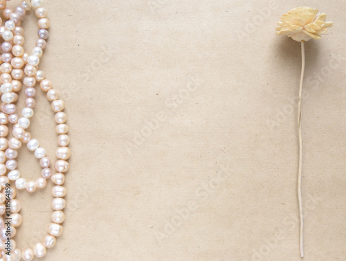 Blank craft background. Sheet of rough paper with rose pearls and flower. Mock up for letter writing, creative work concept