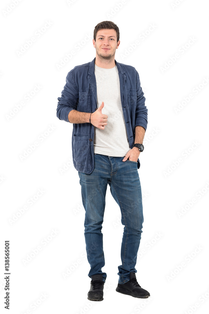 Happy young man in rolled up sleeves in denim shirt with thumbs up gesture. Full body length portrait isolated over white background. Happy young man in rolled up sleeves in denim shirt with thumbs up gesture. Full body length portrait isolated over white background.