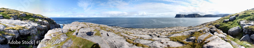 Panorama vom Knivskjellodden mit Felsküste im Vordergrund und Blick über eine Bucht des Atlantik auf das Nordkap auf der Insel Mageroya, Finnmark, Norwegen photo