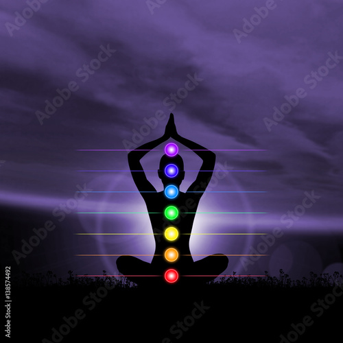 Silhouette trace of human meditating in lotus position. Colored chakra lights over body. Yoga, zen, Buddhism, recovery, religion, healthcare and wellbeing concept.