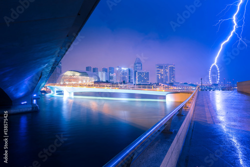 Singapore city skyline with rainy seasons sky lightning.