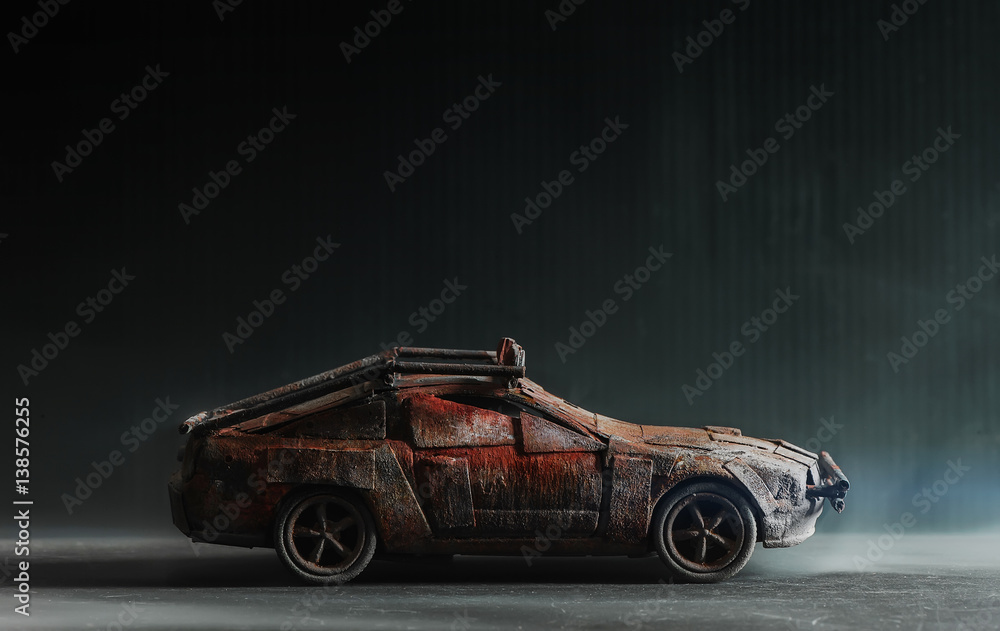 Post - apocalyptic handmade toy car on black background with smoke