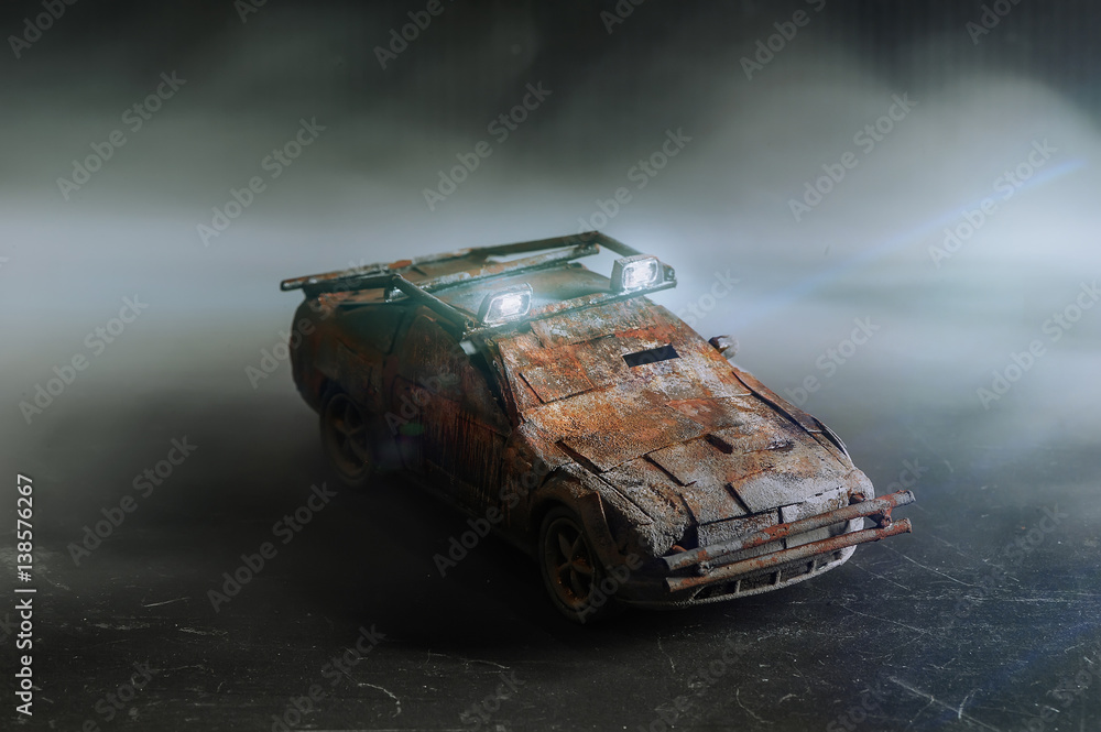 Post - apocalyptic handmade toy car on black background with smoke