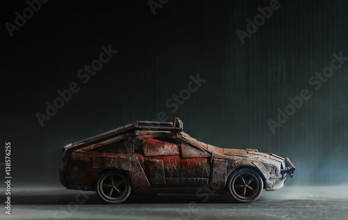 Obraz na płótnie Post - apocalyptic handmade toy car on black background with smoke w salonie