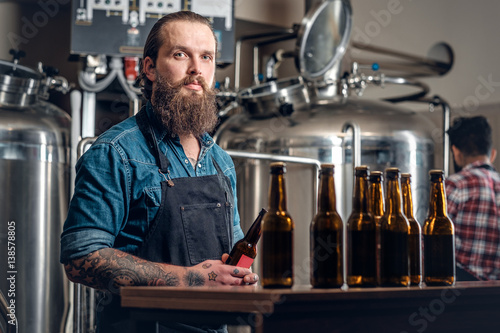 Photos Two men presenting craft beer in the microbrewery.