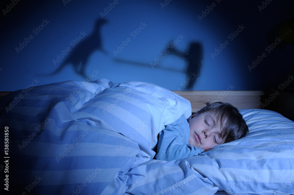 Kind schläft im Bett und träumt von Drachen und Ritter StockFoto