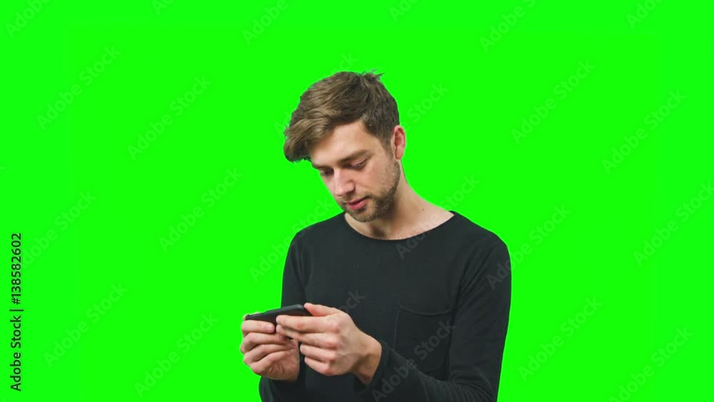 Young man using smart phone playing game, rotate screen on Green Screen Background Young man using smart phone playing game, rotate screen on Green Screen Background