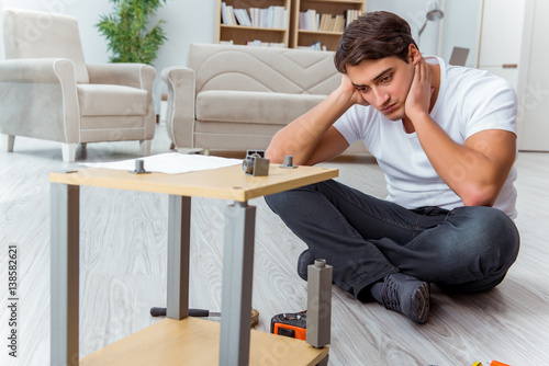 Man assembling furniture at home