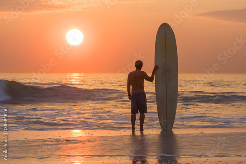 Photography surfer silhouette at sunset with longboard