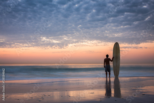 Canvas Print surfer silhouette at sunset with longboard
