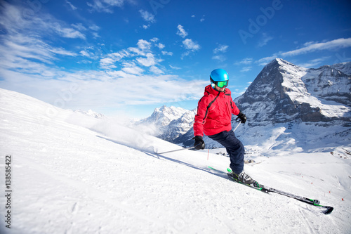 Young attractive caucasian skier on ski slope in famous Jungfrau ski resort in Swiss Alps, Grindelwald, Switzerland