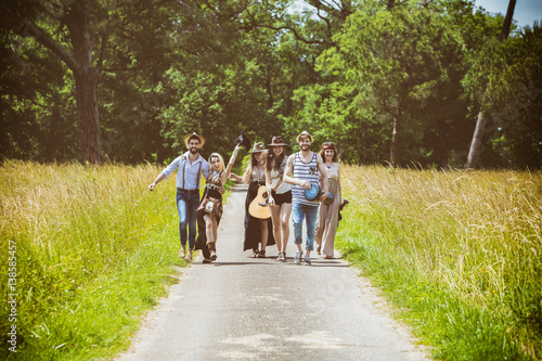 Groupe de jeunes Hipster de face, marchant sur la route de campagne