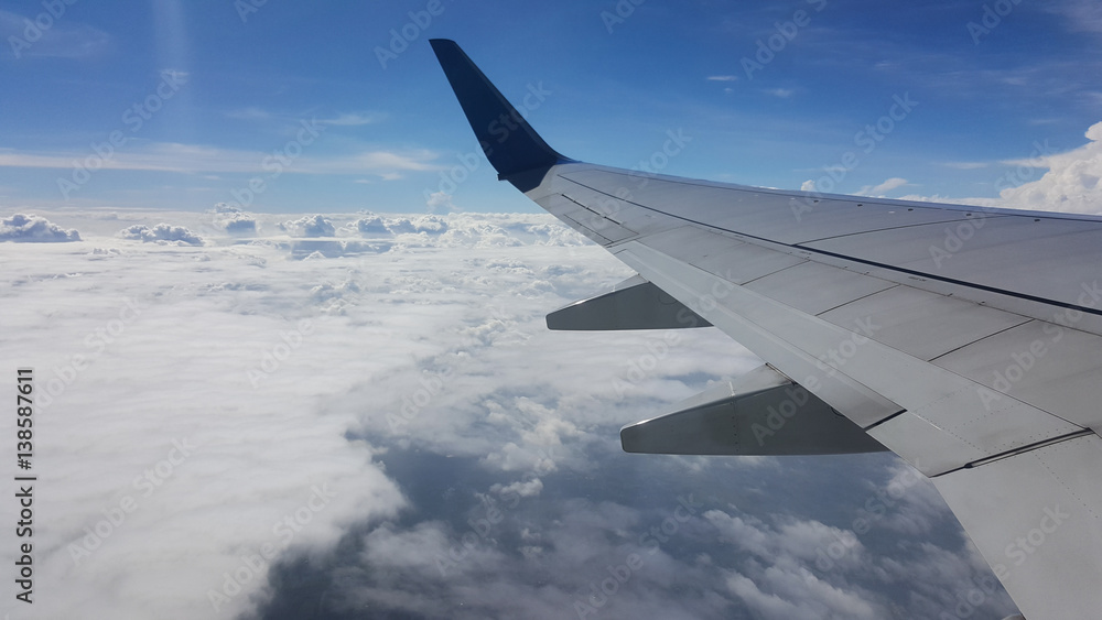 Wing airplane over the blue sky and cloudy while flying Wing airplane over the blue sky and cloudy while flying