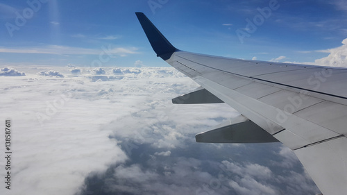 Wing airplane over the blue sky and cloudy while flying