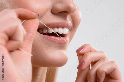 Cute girl using dental floss photo