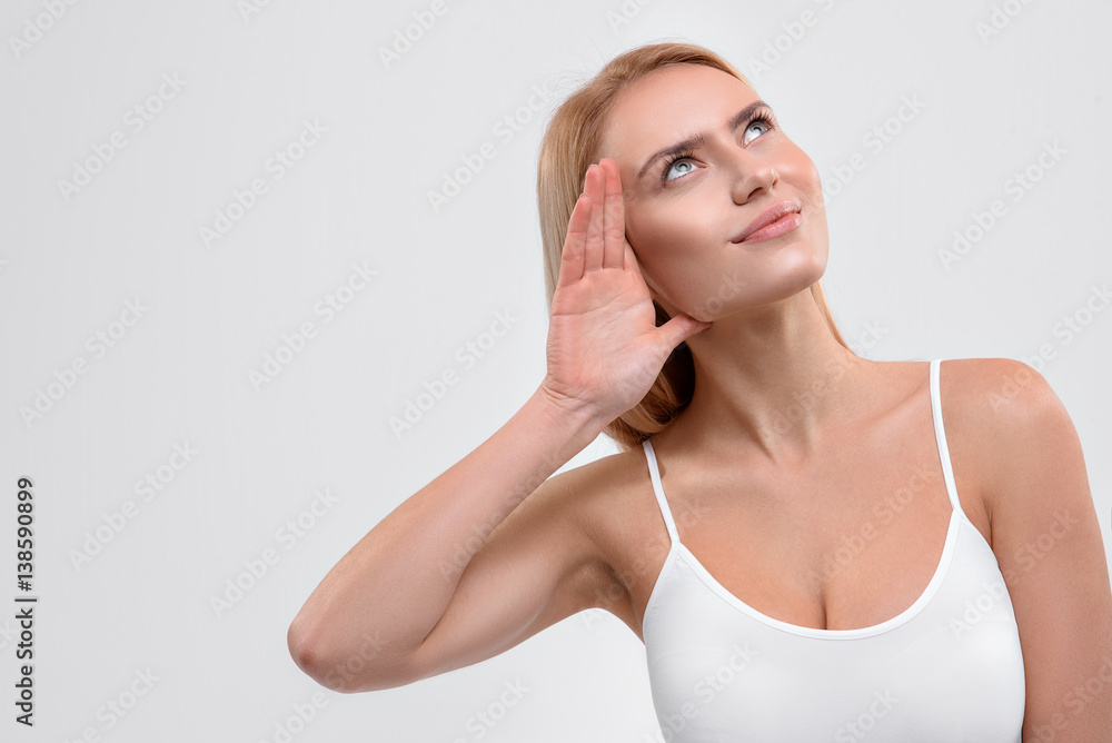 Cheerful young woman trying to hear something Cheerful young woman trying to hear something