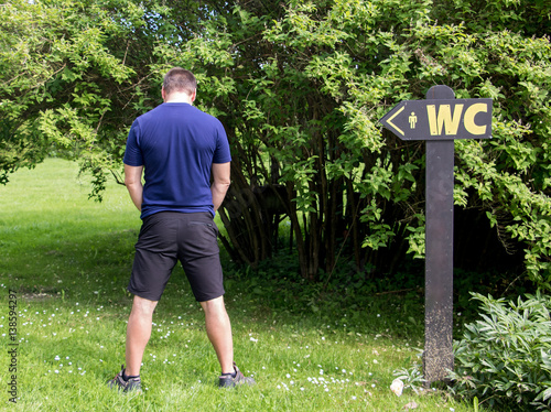 Obraz na plátne man urine in the countryside beside signs toward the WC