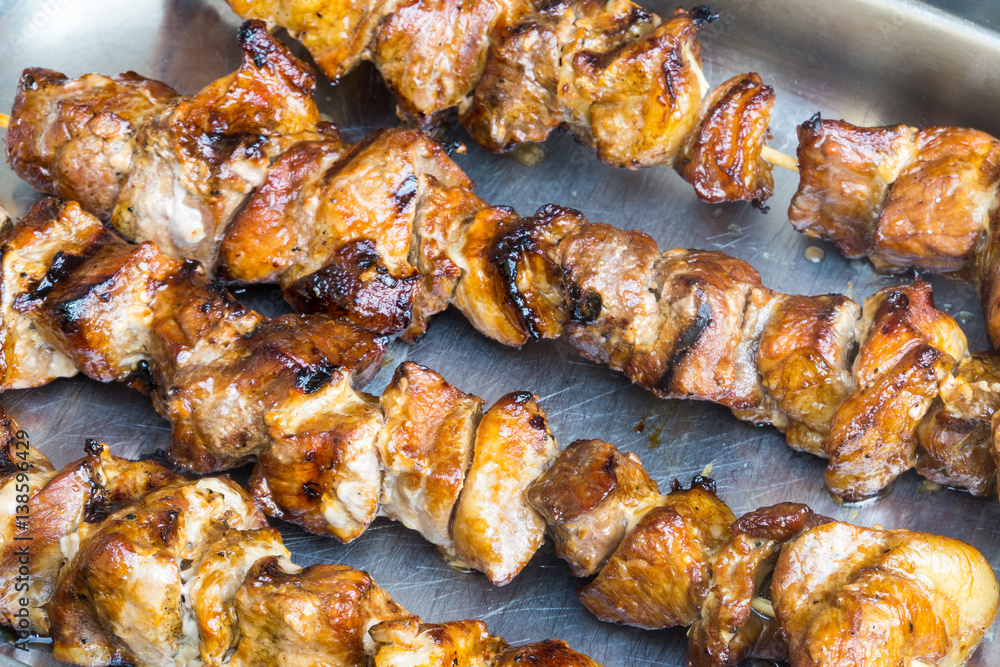 A pork skewer stick on the grill