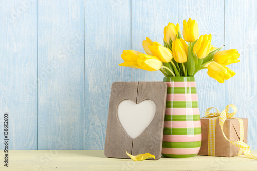 Fresh yellow tulips, gift box and heart shaped frame