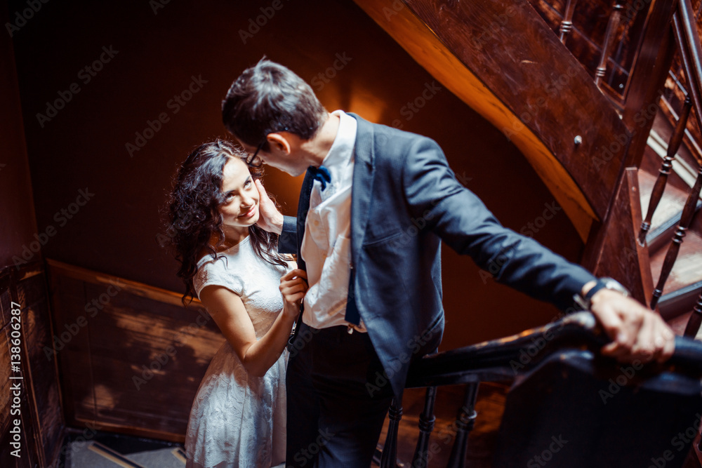 Fashionable young couple standing on stairs and hugging each other