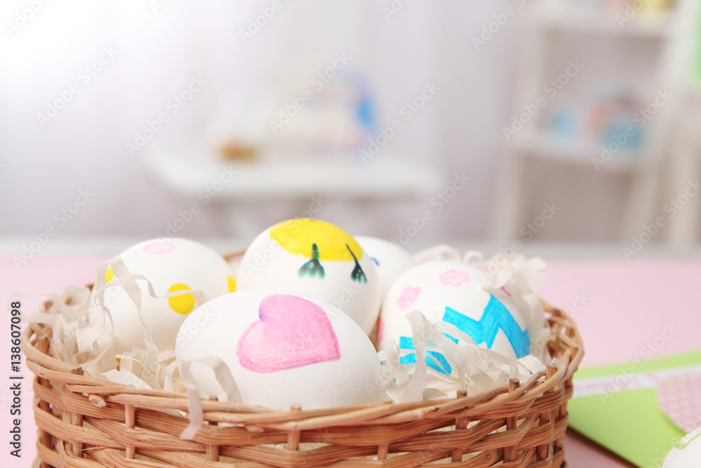 Fototapeta premium Wicker basket with Easter eggs on blurred background, closeup