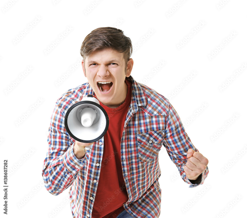 Protesting young man shouting into megaphone on light background Protesting young man shouting into megaphone on light background
