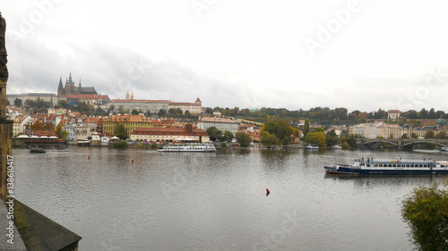 Prague, Czech Republic - October 8, 2015 :  Charles Bridge view on Vltava river, boats, residence, buildings, city and Old town. Mobile photo. Famous tourist and traveler routs.